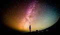 Person, standing and looking up into the stars and the Milky Way.
